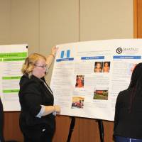 People putting up their presentation posters, preparing for the showcase to begin